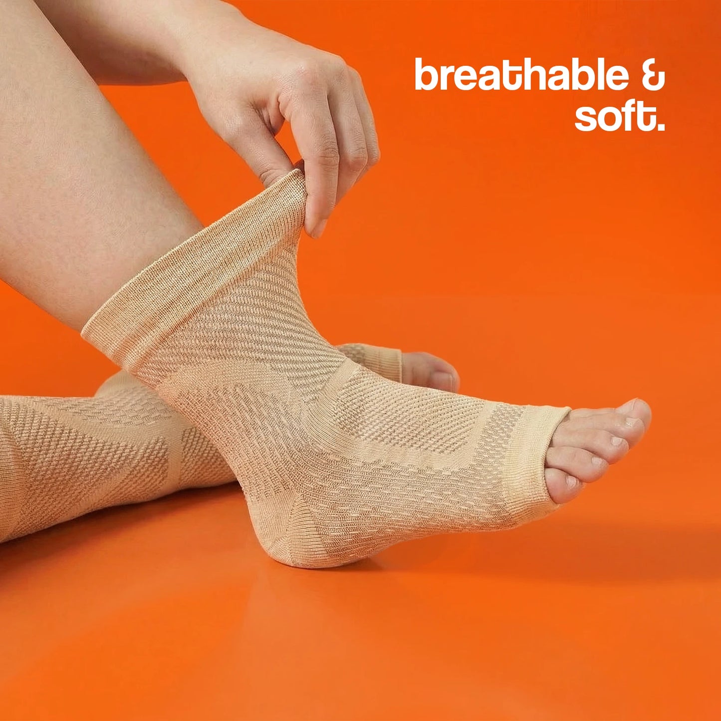 Compression socks in beige being pulled on, featuring a breathable and soft texture against an orange background.