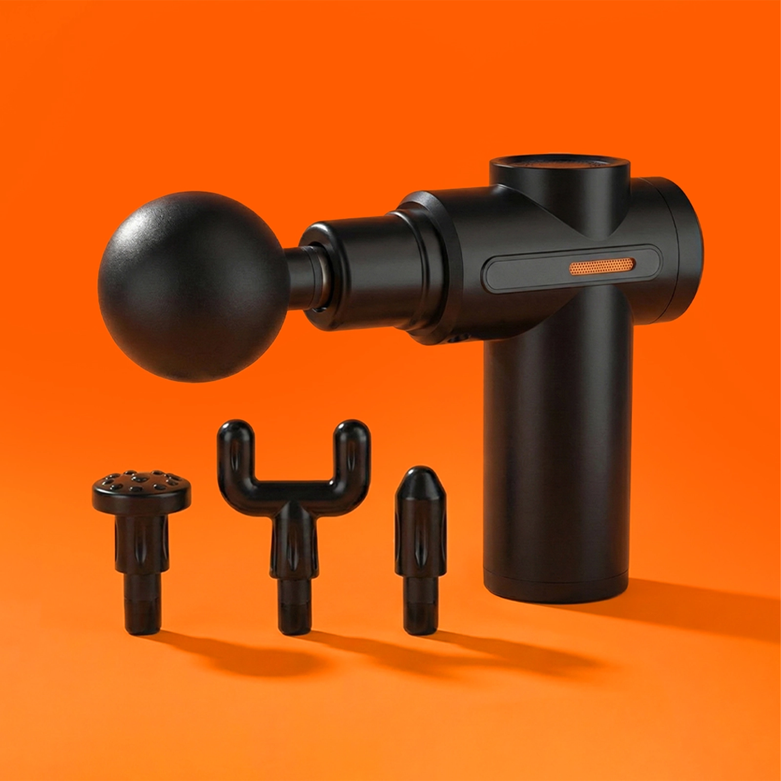 Black massage gun on an orange background shown with three extra attachments.